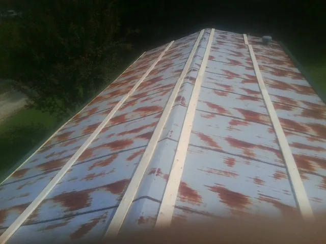 Rusted metal roof panels with new wood purlins before replacement — Storm Damage Roof Repair in Russia by Roofing Brothers