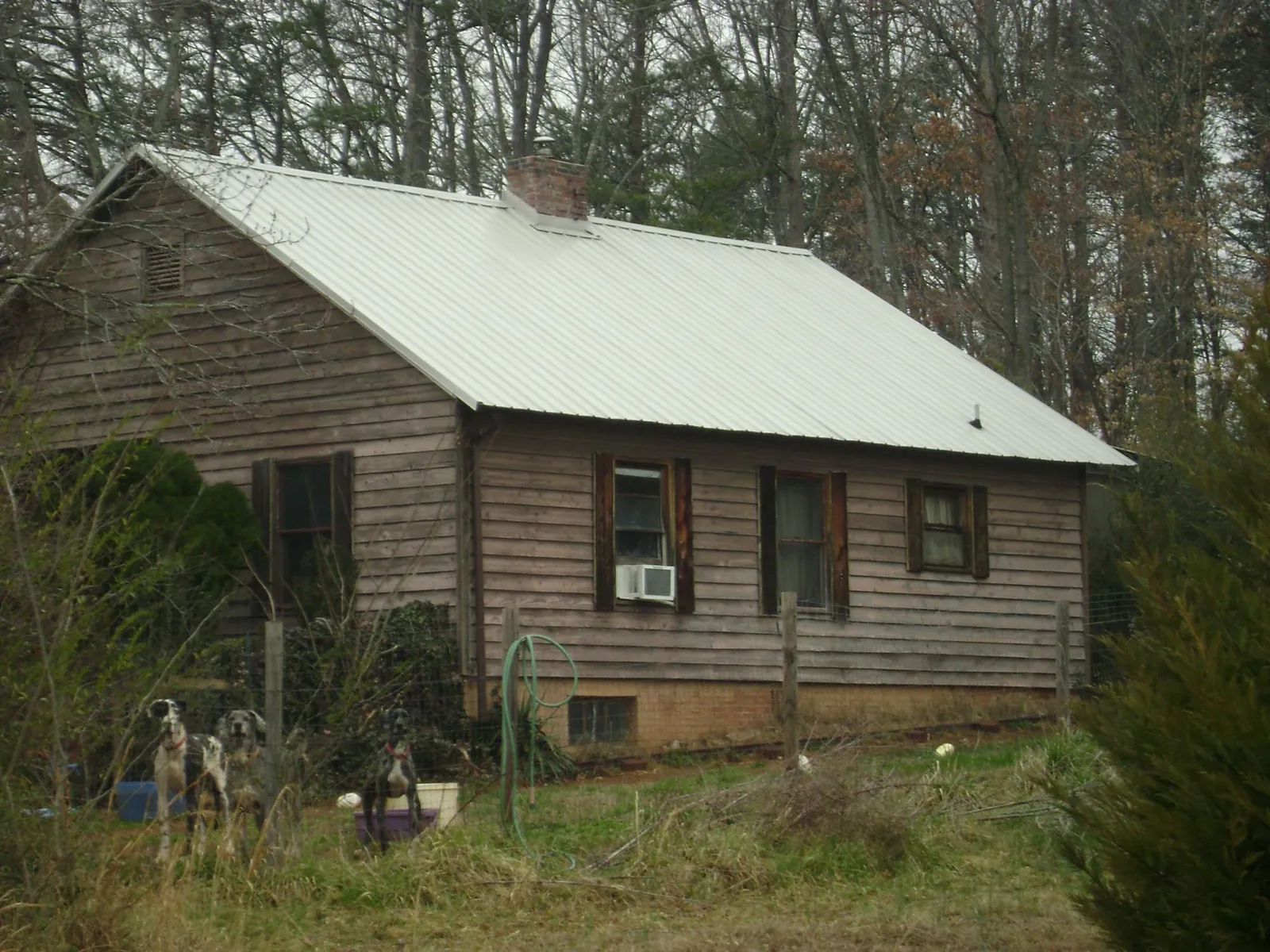 White metal roof on an old wood sided farmhouse, from a Metal Roof Installation job in Russia